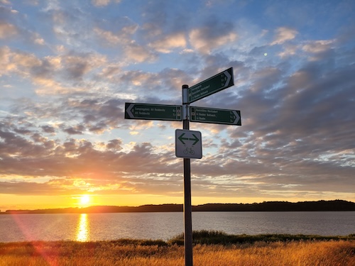 Sonnenuntergang mit Wegweiser